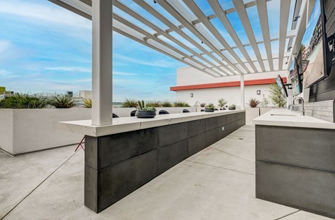 A modern outdoor seating area with a white pergola and concrete structures.